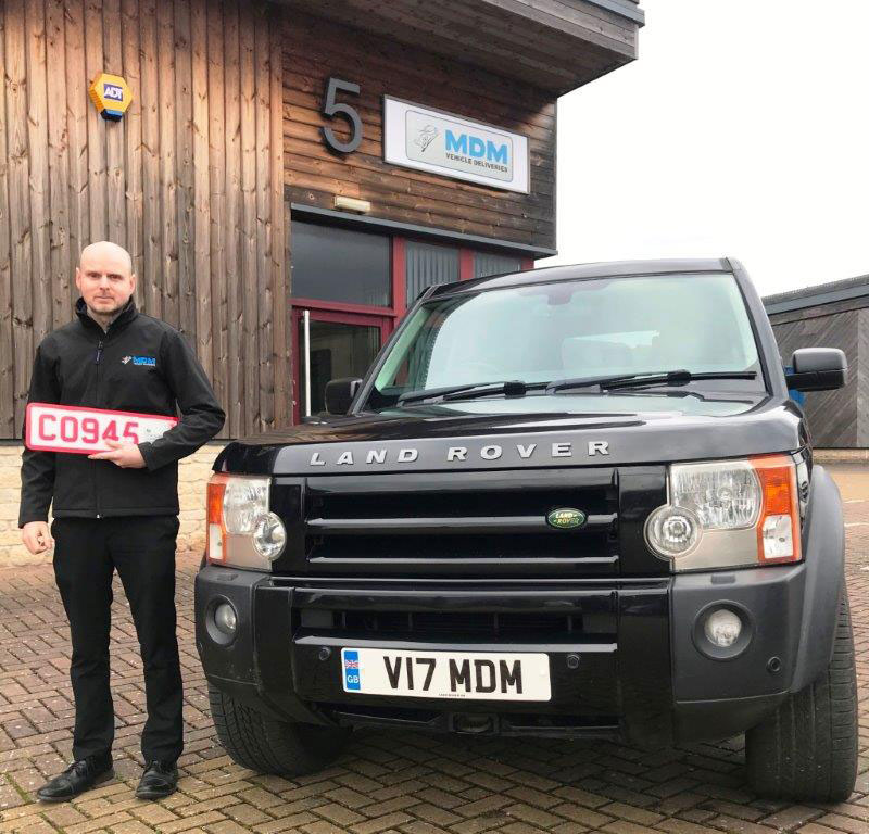 An MDM trade-plate driver holding number plates